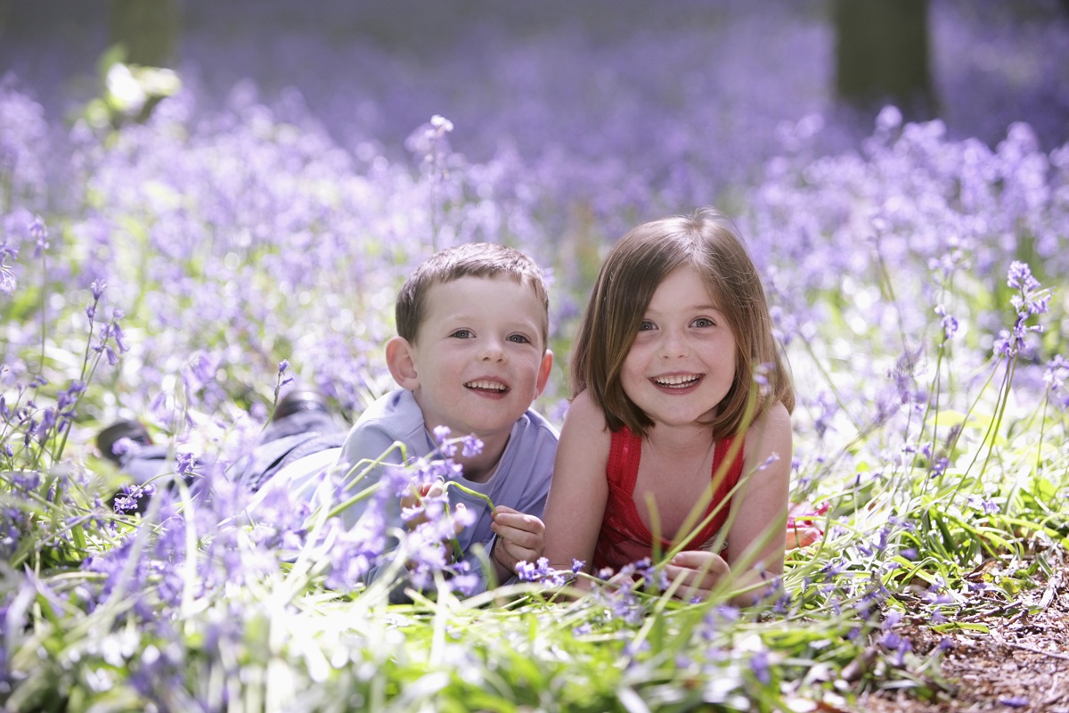 boy and girl laying in flowers