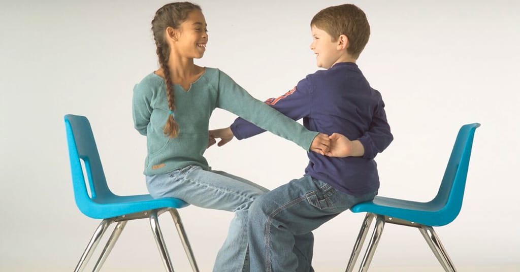 Children Doing Partner Pose While Sitting
