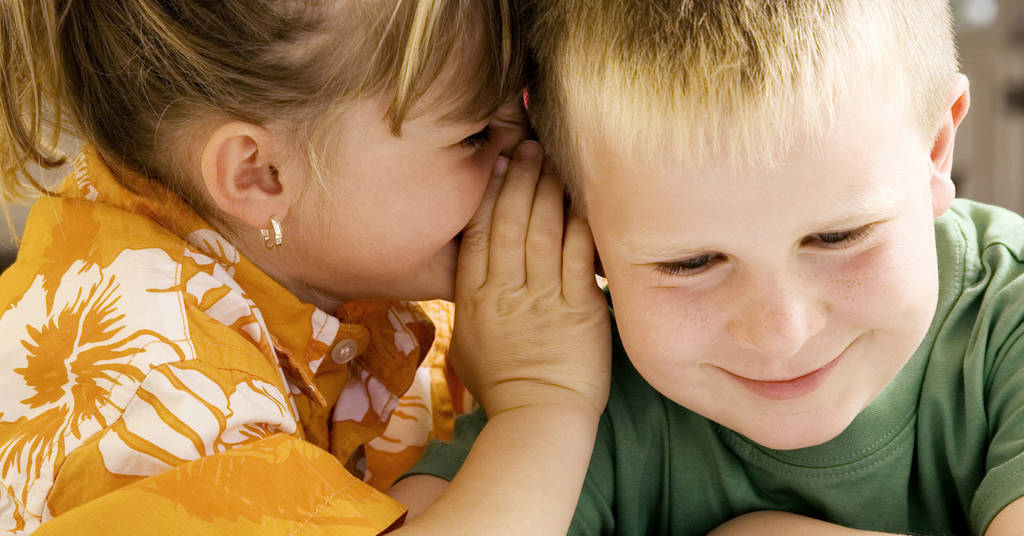 Girl Whispering in Boy's Ear