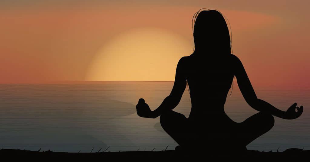 Woman Meditating on Beach