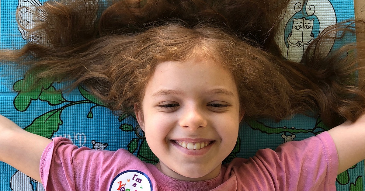girl smiling on yoga mat